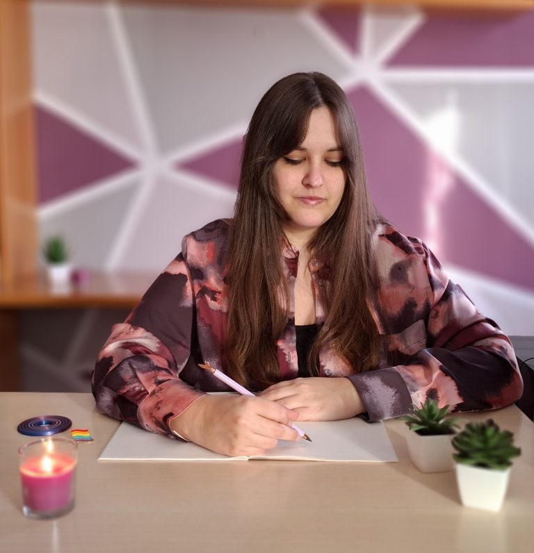 Psicóloga en su espacio de trabajo escribiendo en una libreta, en un entorno de acompañamiento terapéutico inclusivo